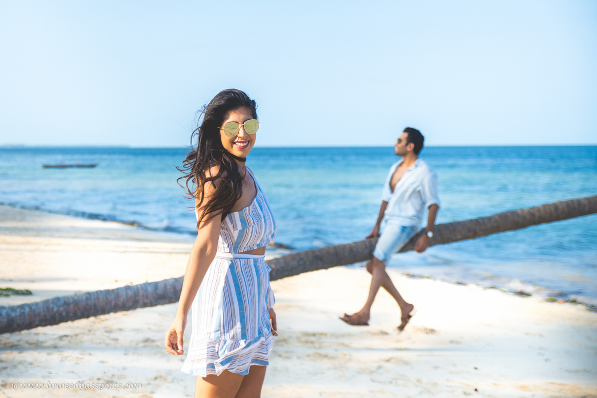Couple enjoying a sunny day on a beautiful Zanzibar beach, with turquoise waters and a relaxed tropical vibe.