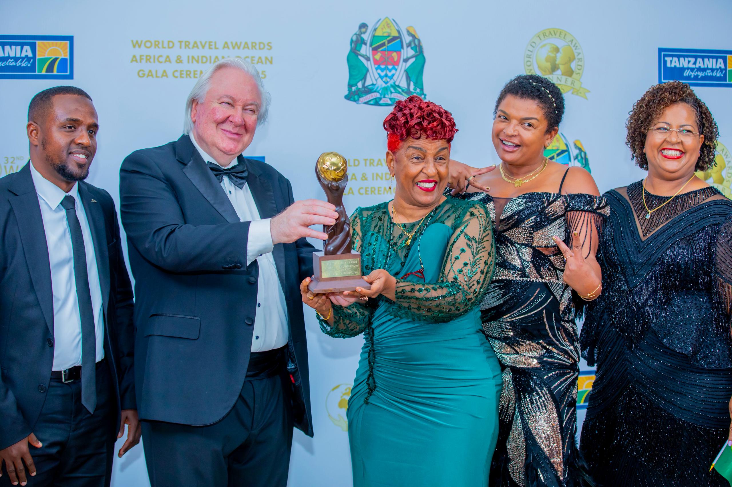 Zainab Ansell and the Zara Tanzania Adventures team receiving the Africa’s Leading Adventure Tour Operator award at the World Travel Awards Africa & Indian Ocean Gala Ceremony, smiling and holding the trophy together.