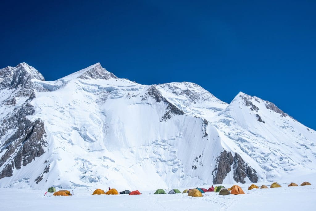 Climbers’ base at 5,900 m on Gasherbrum II under bright alpine light.