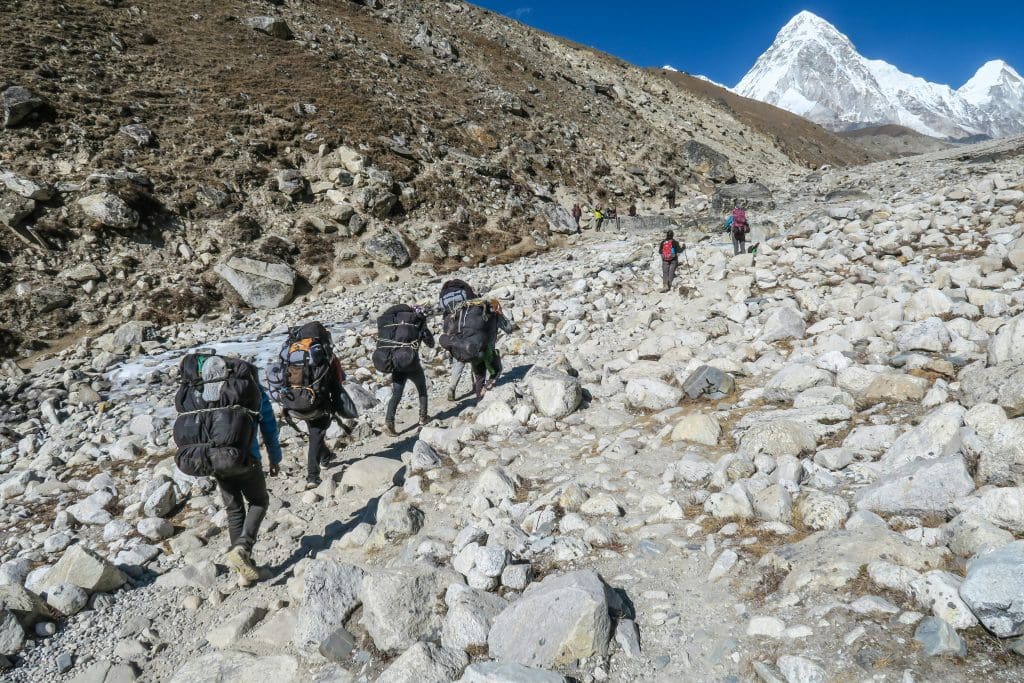 Trekkers carry backpacks with essential items needed along the Everest Base Camp trail.